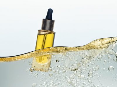 The bottle of the yellow cosmetic oil in the yellow  oil emulsion wave